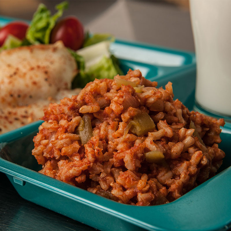 Side view of Spanish Brown Rice on a school lunch tray.