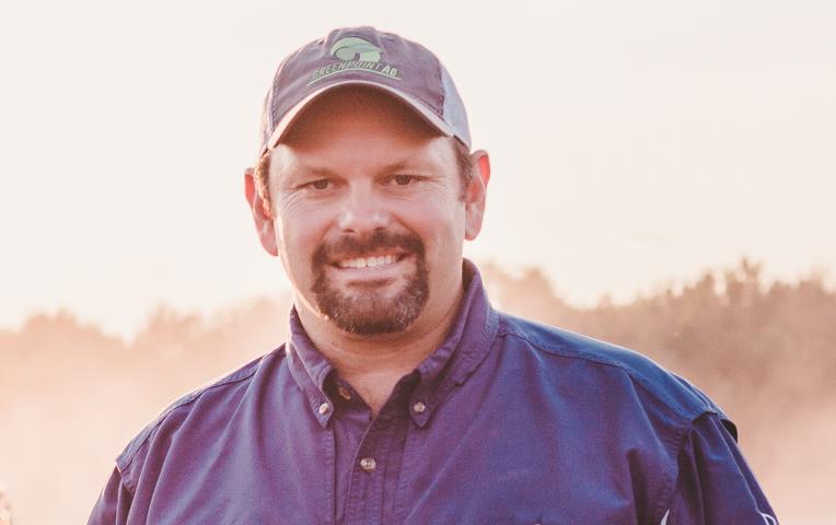 LA rice farmer Jason Waller, headshot, white man with mustache and goatee wearing blue button-down shirt and baseball cap