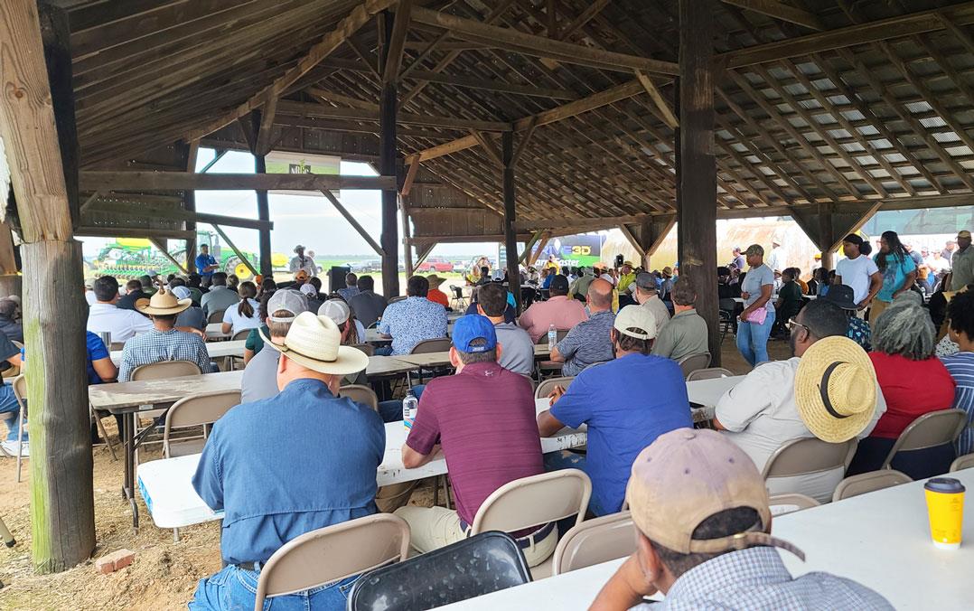 NBGC-Field-Day, a crowd of people sit under a farm shed cover in the shade