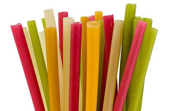 Colorful straws made out of rice sticking out of a wooden cylinder