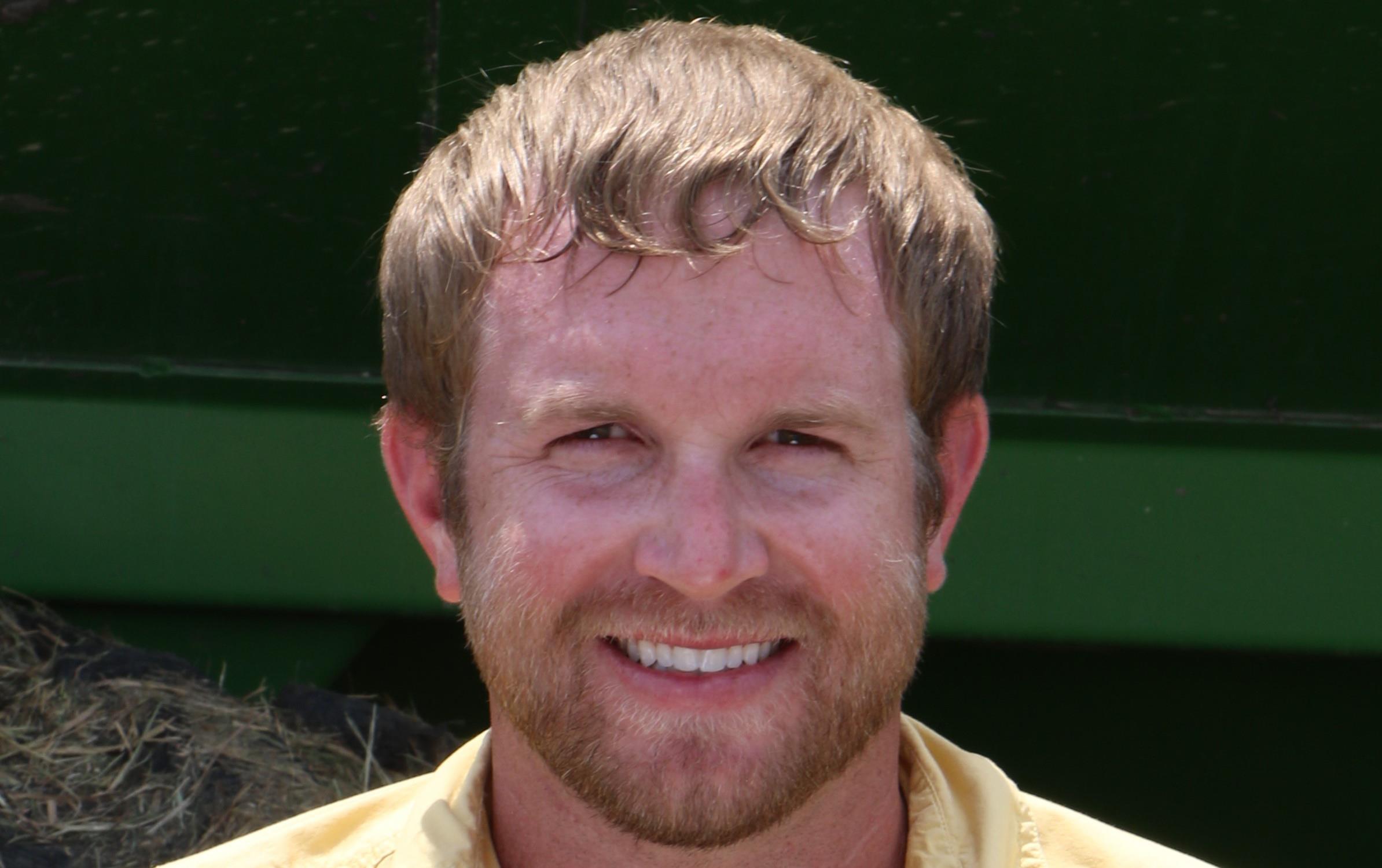 Texas rice farmer Scott Savage, wearing yellow shirt, holding paddy rice in hands