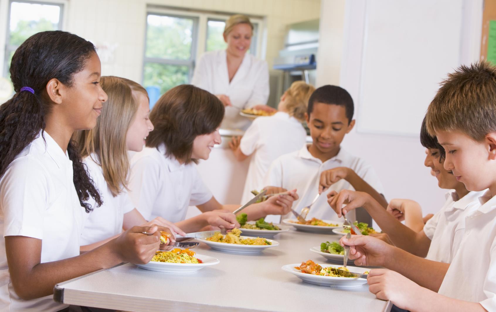 Group of students eat lunch at cafeteria table