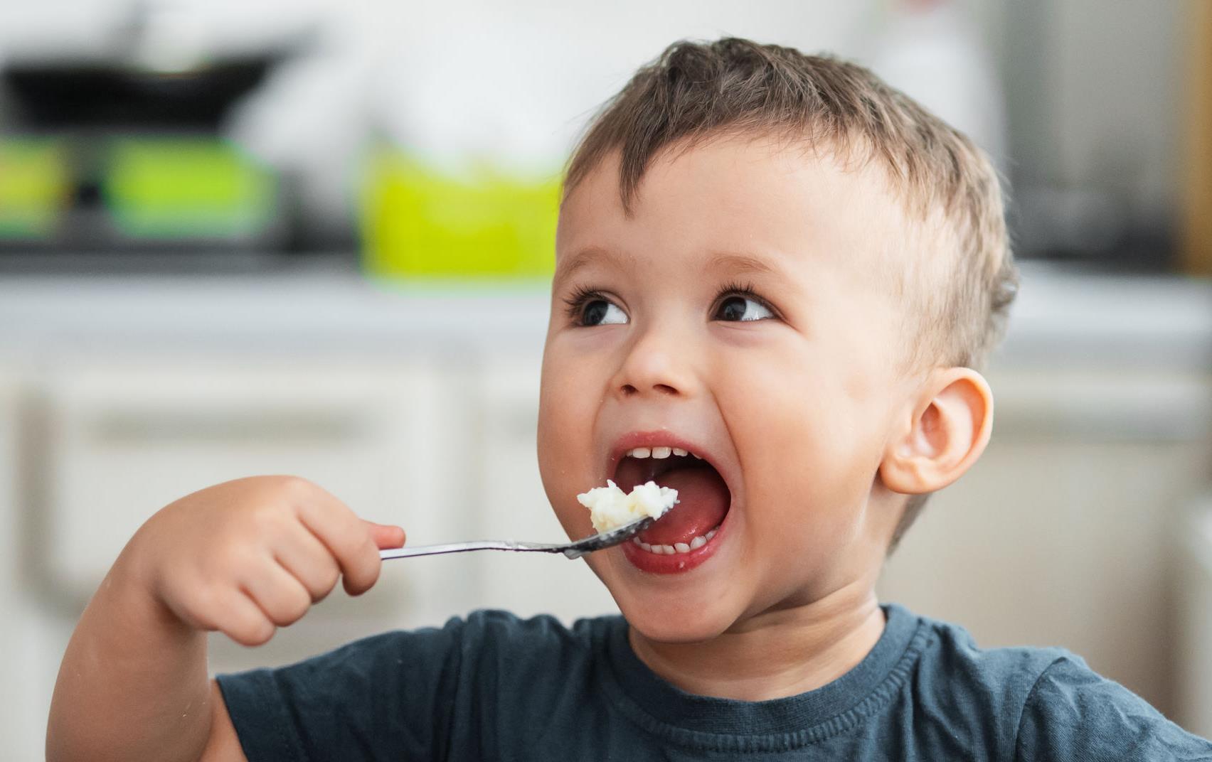  Male toddler eating rice with spoon