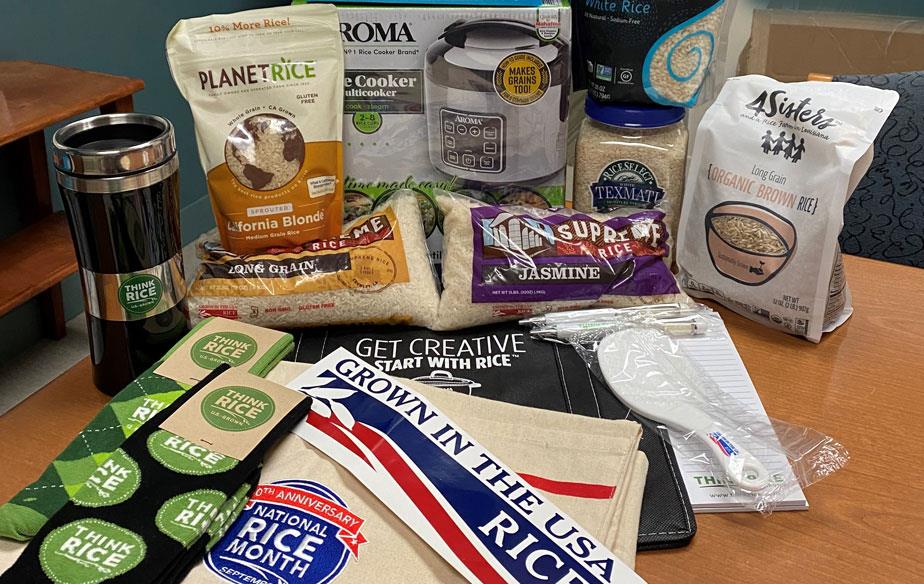 NRM-Prize pack items, including bags of rice, bumper stickers, socks and rice cookers, piled on a desk