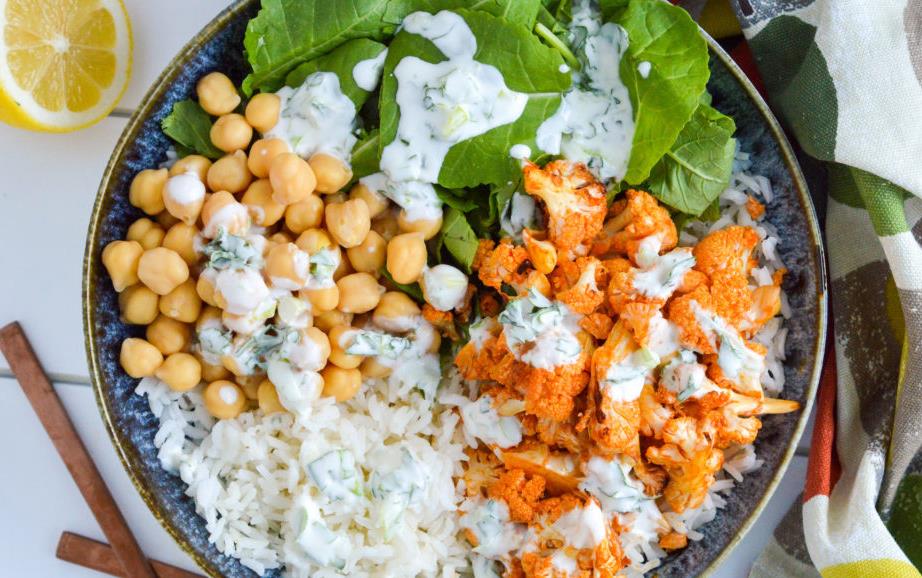 Blue bowl filled with rice, chickpeas, roasted cauliflower and spinach