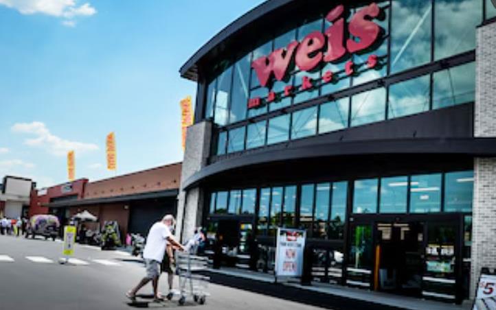 Weis-Mkt-storefront with man pushing shopping cart across parking lot