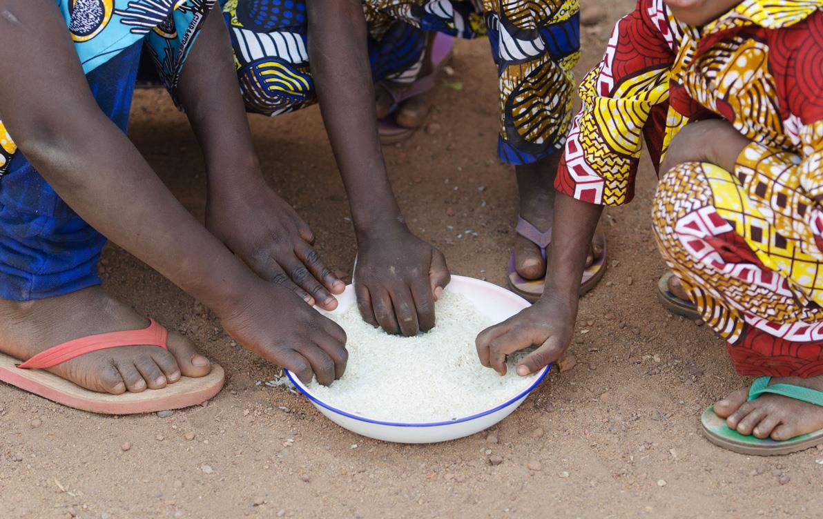 Dark-hands-reach-into-bowl-of-white-rice