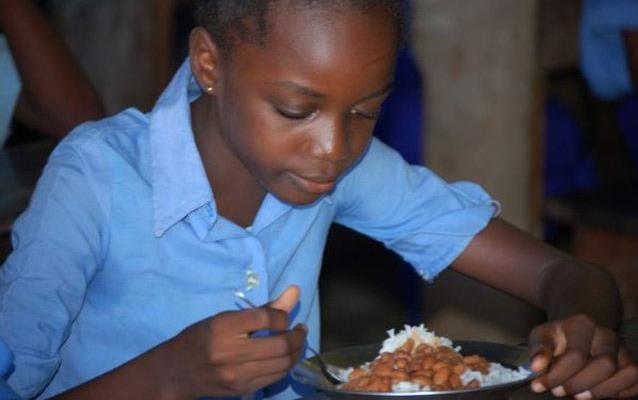 Young-girl wearing blue shirt, eating-rice-&-beans,-Pointe Noire