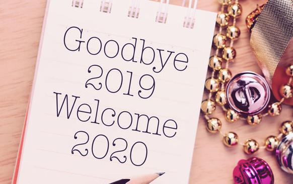 "Goodbye 2019 Welcome 2020 written on memo pad surrounded by glittery buttons and beads