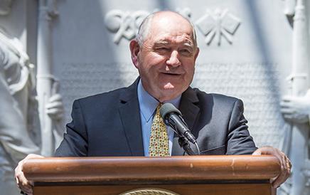 Secy Sonny Perdue stands at podium adorned with the USDA seal