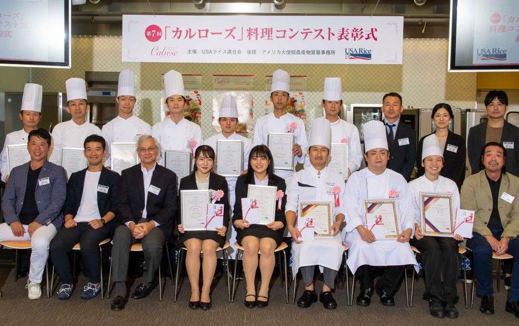 Group shot of chefs wearing toques and other people wearing business attire