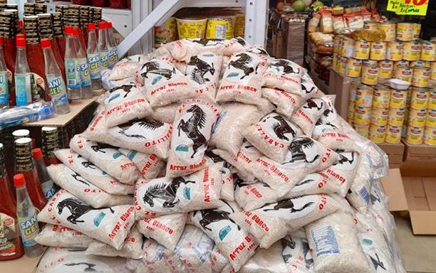 US-grown rice packaged in plastic bags stacked on floor of grocery store in Guatemala