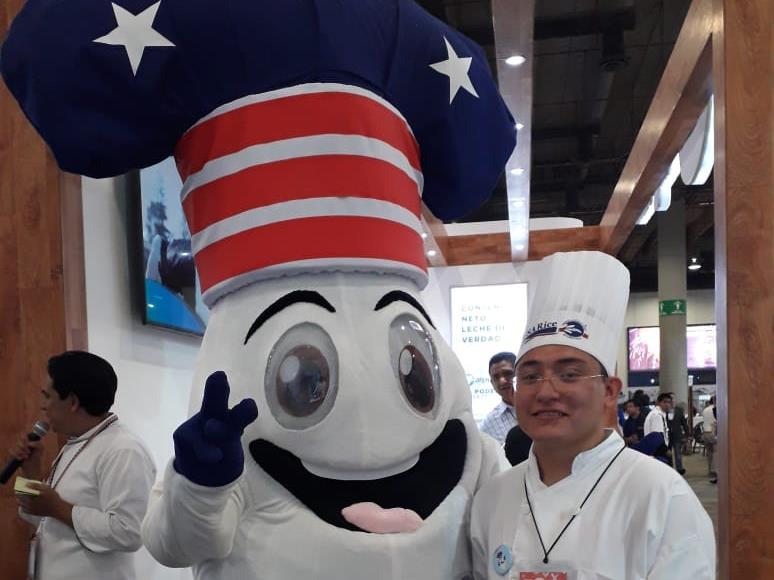 Rice mascot with big eyes and wide open mouth, wearing red, white & blue chef