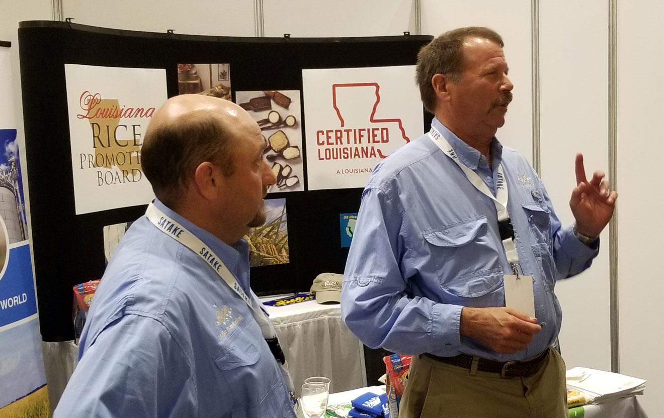 Three men stand in front of booth promoting Louisiana rice