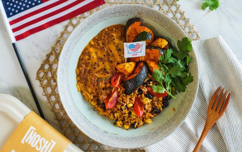 Bowl of chili on bamboo placemat flanked by American flag and wooden fork