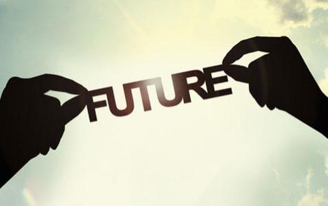 The word "future" held up by two hands, silhouetted against a bright sky