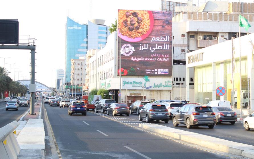 Saudi street scene with traffic driving under USA Rice billboard