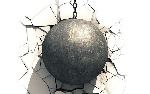 Iron wrecking ball smashes into white wall 