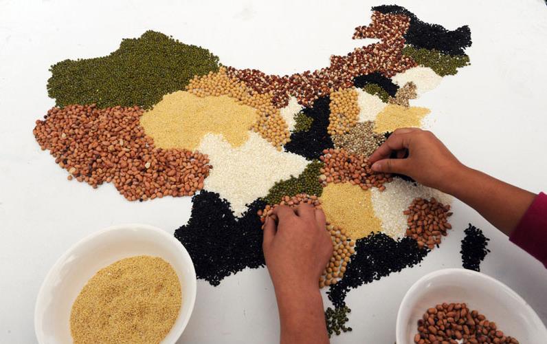 Two hands creating map being made with colorful grains