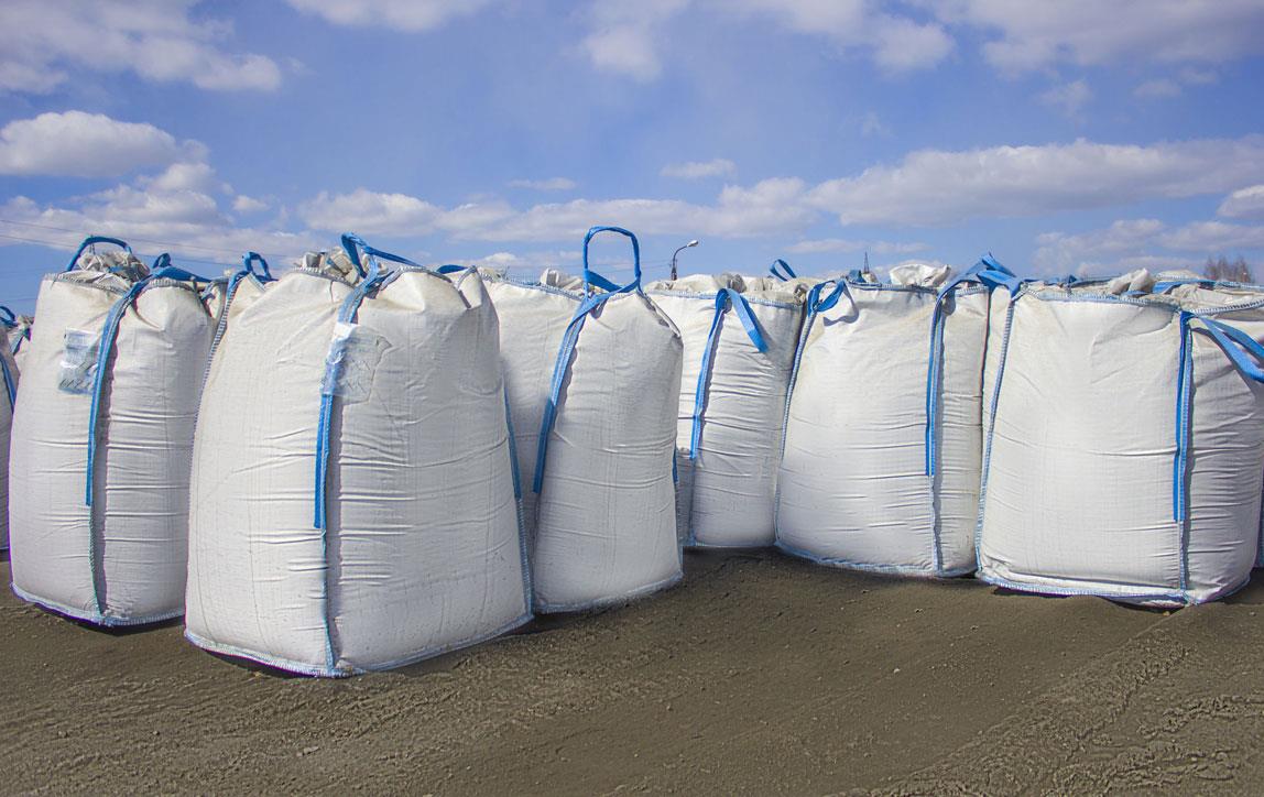 Large-white rice-sacks-lined-up, blue sky in background