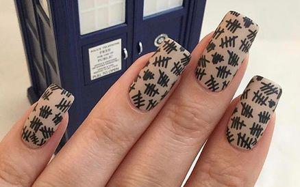 Black tally marks painted on manicured nails