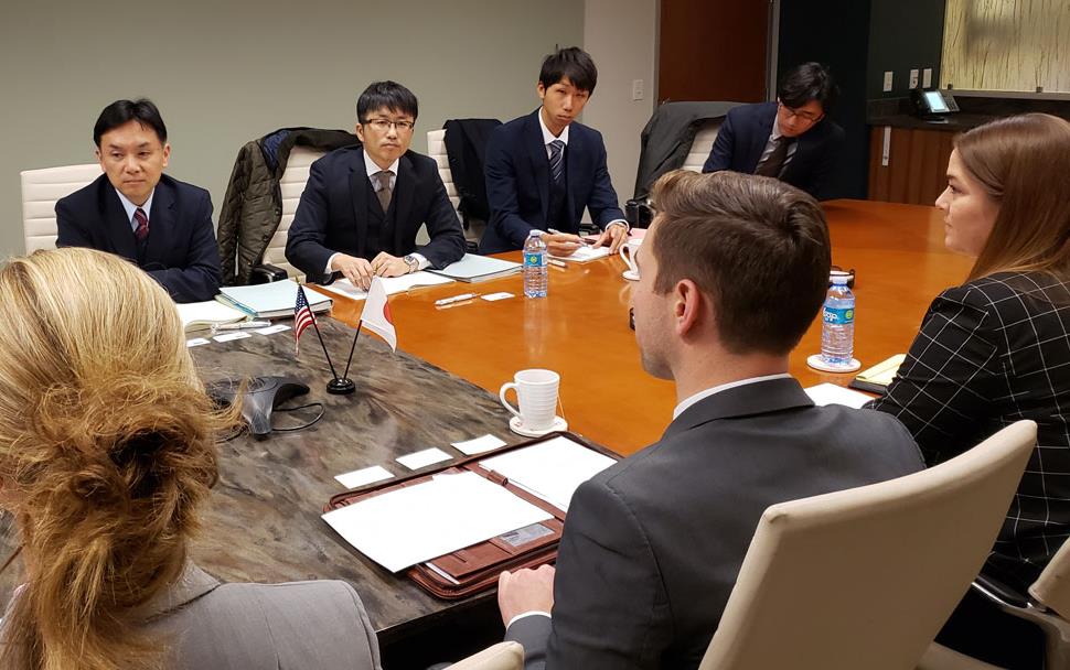 Group shot of people sitting around conference room table