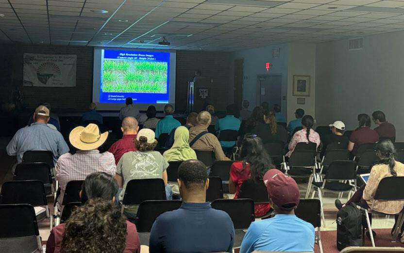 2024-Beaumont-TX-Field-Day,-attendees seated in front of viewing screen listen to research presentation