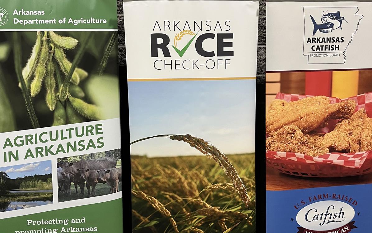 Three banners on display at the AR Grown Conference show soybeans, rice, and catfish