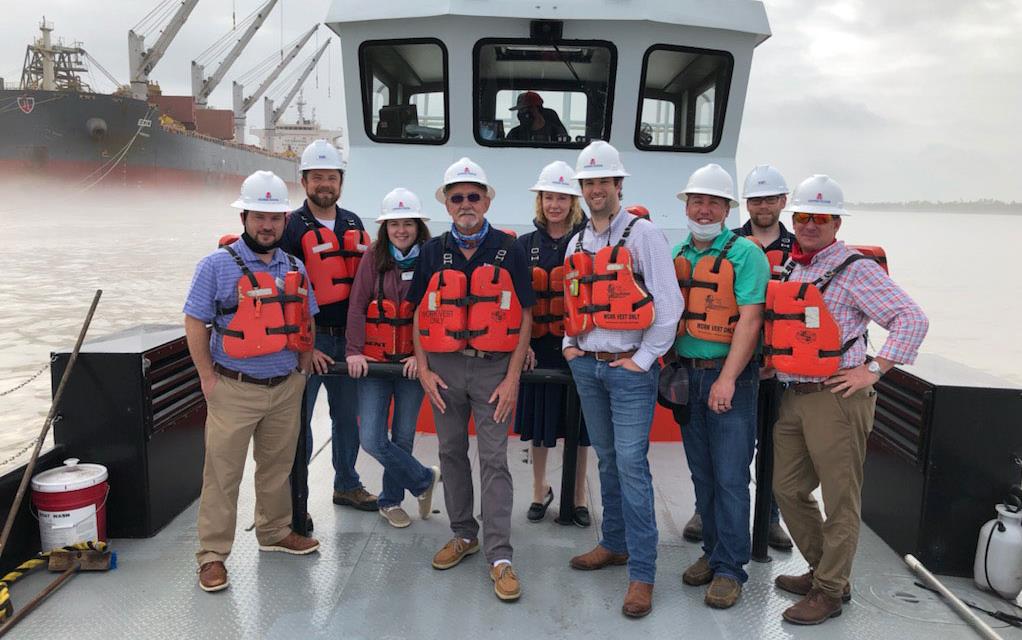 Leadership-Class-on-MS-River, group shot of people wearing orange life jackets standing on boat deck