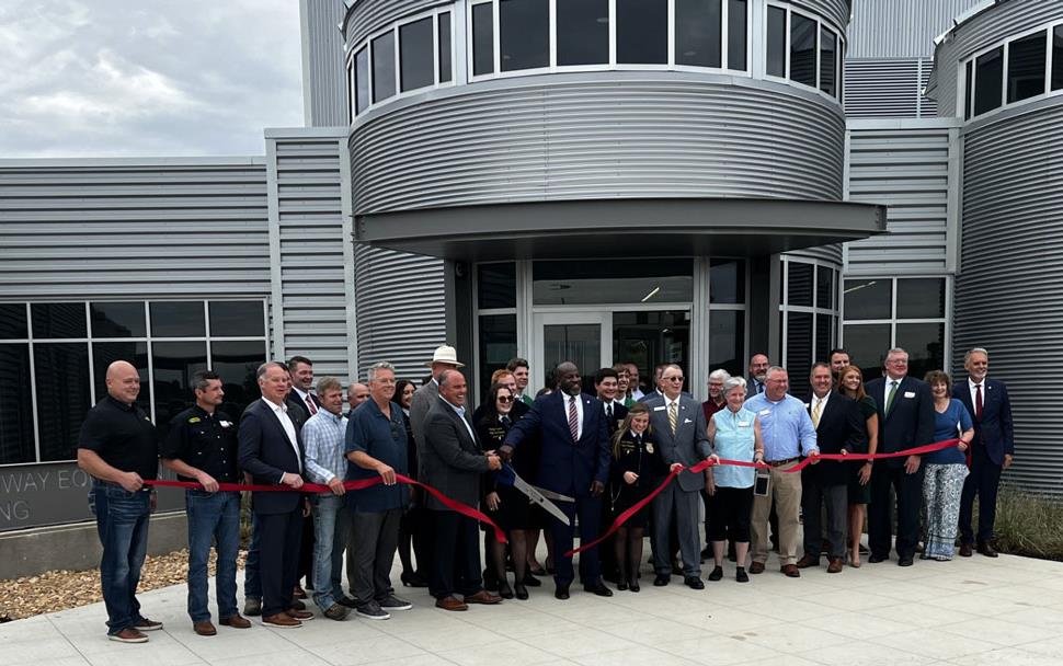 NERREC-Ribbon-Cutting-Ceremony,-outside with large group holding red ribbon