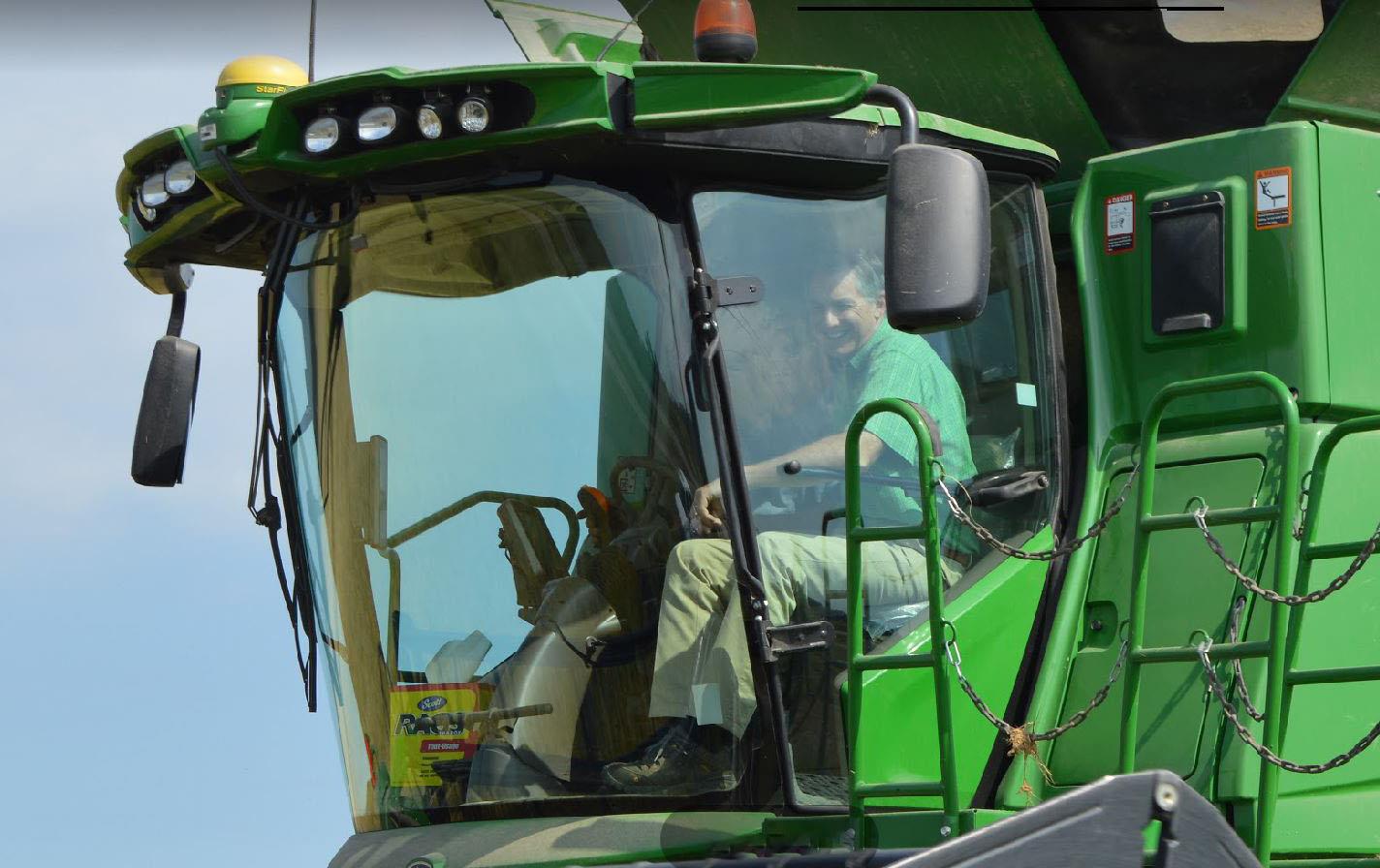 Close up of Rep French Hill in cab of green combine