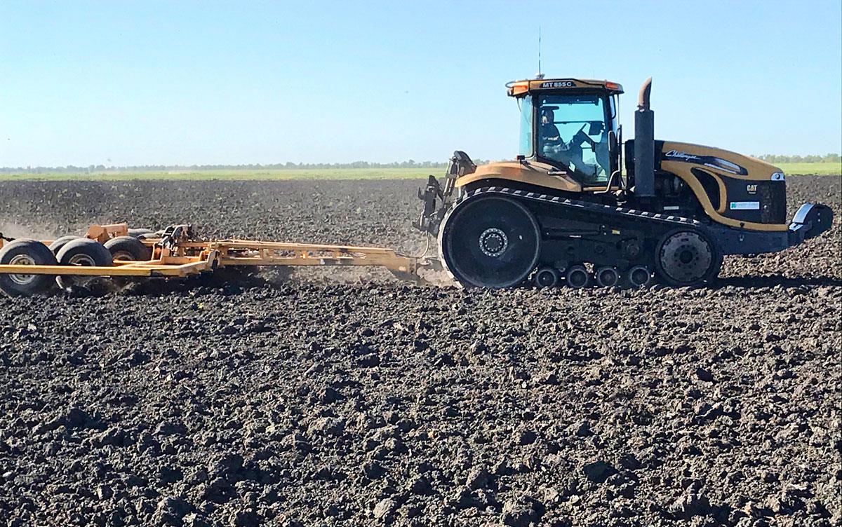 Yellow tractor in field of fresh dirt