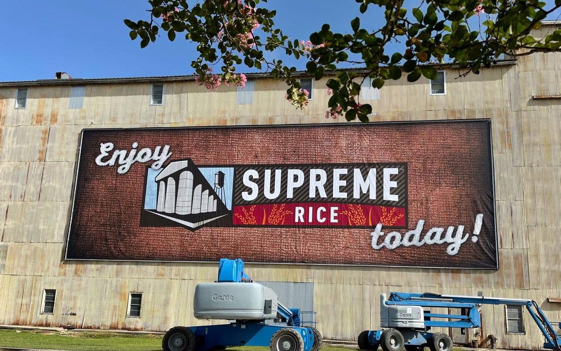 Supreme-Rice-sign-on-building with equipment in front