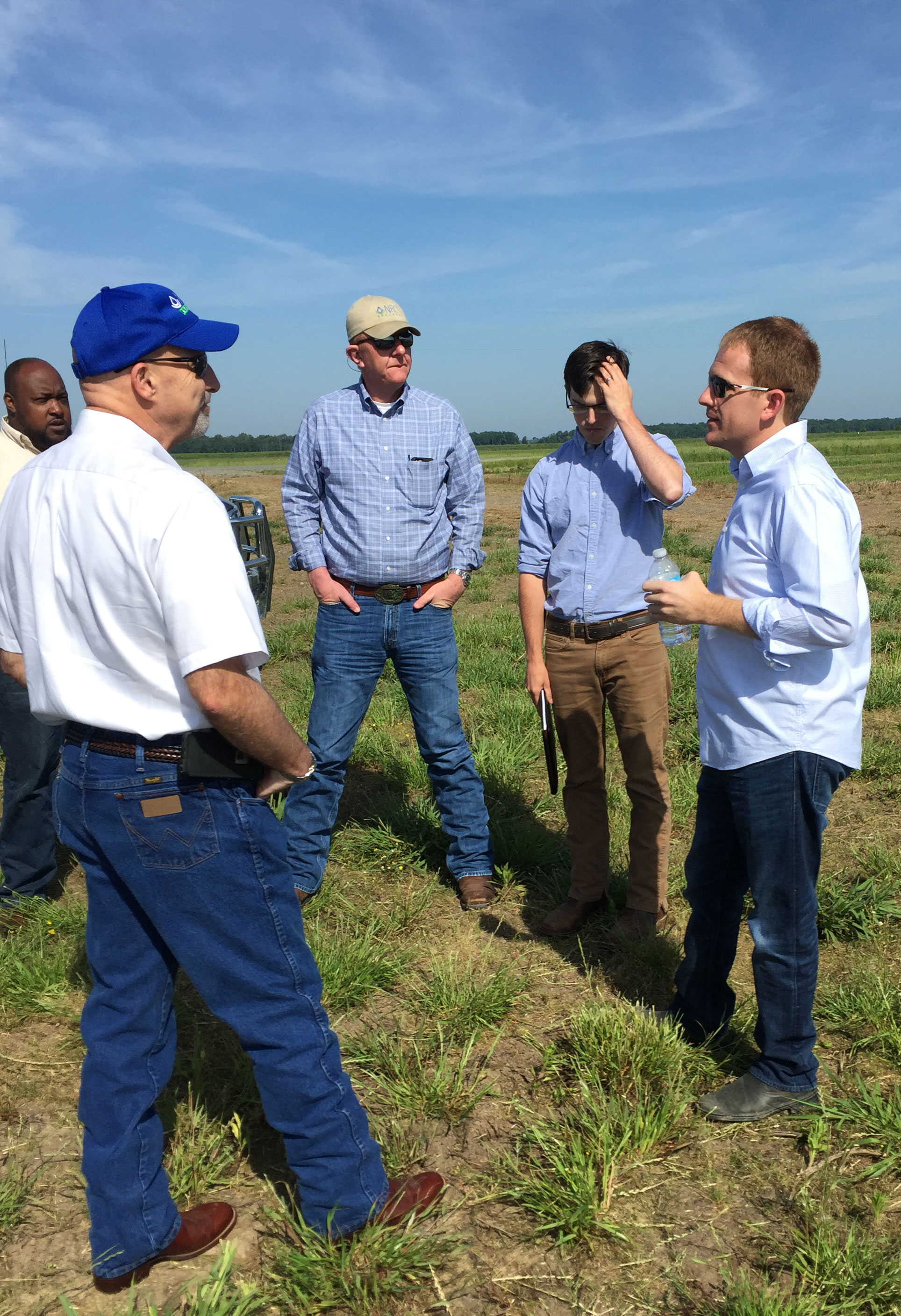 group of men speak in field