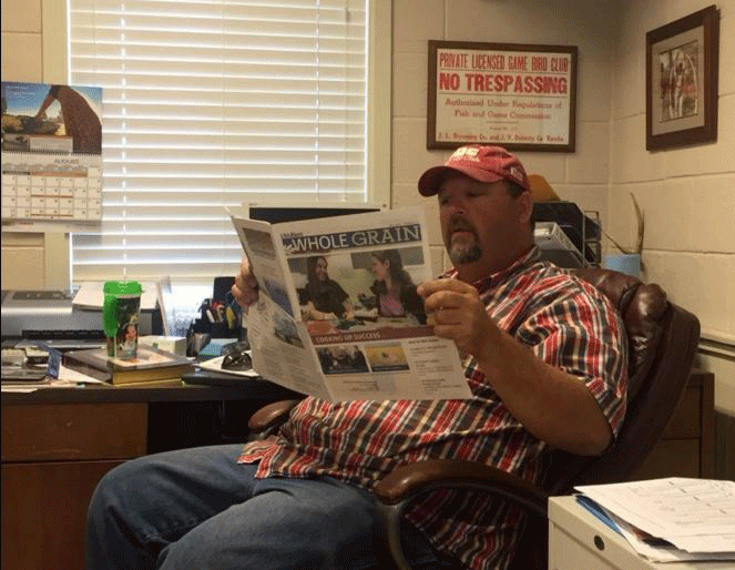 Sean-Doherty- sitting in office chair reading Whole Grain