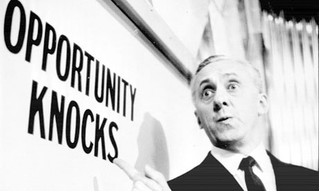 Man pointing to a sign that reads "Opportunity-Knocks"