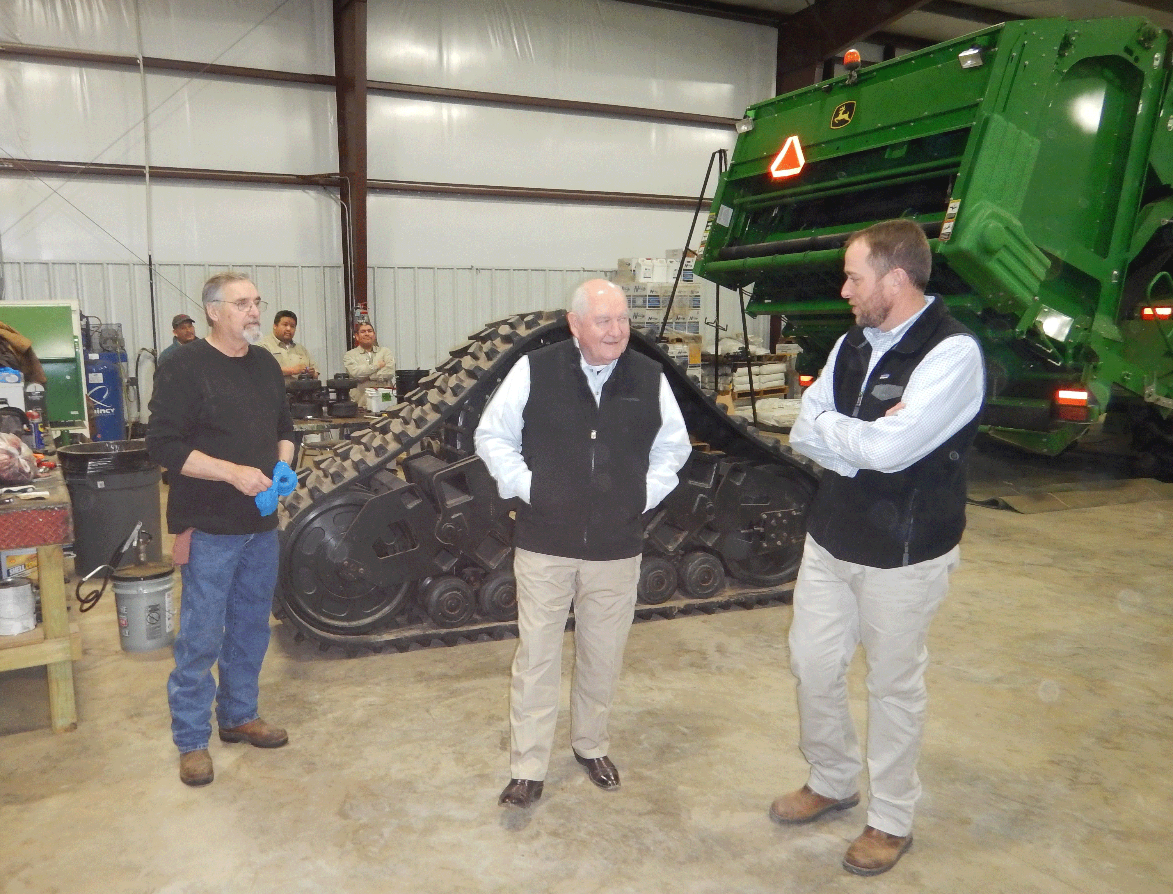 Ag Secy-Perdue visits Dow-Brantley operation, surrounded by workmen repairing farm equipment